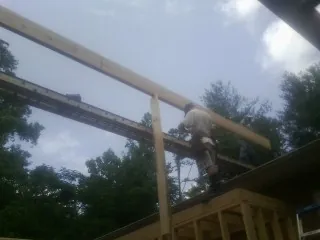 Carpenter setting a ridge beam over a new addition frame — Ice Dam Removal by Roofing Brothers in Trenton