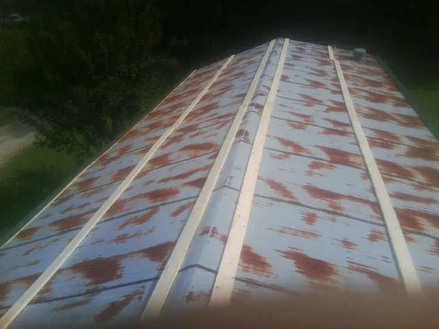 Rusted metal roof panels with new wood purlins before replacement — Storm Damage Roof Repair in Trenton by Roofing Brothers